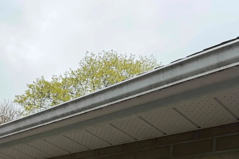 Before: White eavestrough and soffit with grey streaks and oxidation