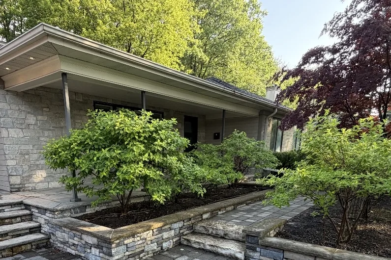 Before: Front interlock walkway and stone retaining walls darkened with dirt